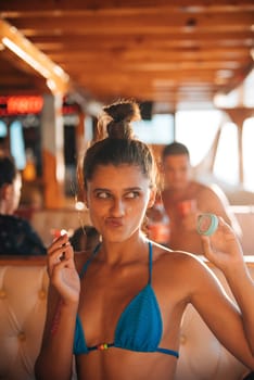 An incredibly playful woman delights in a lively and vibrant moment aboard a boat, basking under the warm sun