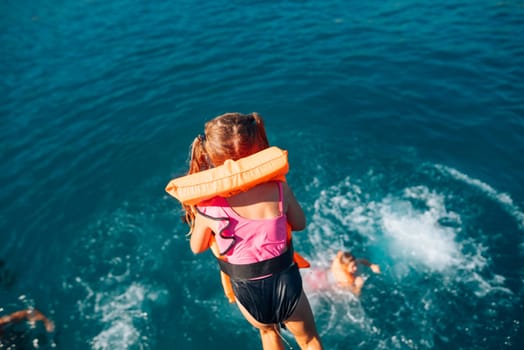 A joyful child energetically jumps into the refreshing water, embodying both summer fun and safety with a life jacket
