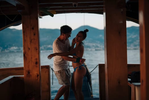 A loving couple shares a beautiful and romantic moment as they dance together on a boat during a stunning sunset view
