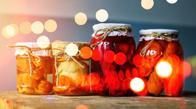 A delightful display of jars filled with vibrant homemade preserves catches the warm glow of fairy lights, creating a charming atmosphere in a cozy kitchen.