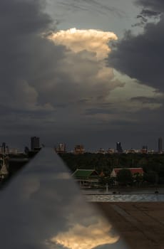 The sky is being covered with amazing clouds with reflection on stainless steel handrail with city view alongside river. Concept idea of Imaginative clouds background, Nature abstract composition for wallpaper and text, Selective focus.