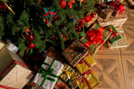 Many boxes of Christmas gifts in eco-friendly craft paper packaging and twine on the floor under Christmas tree