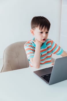 Schoolboy At Table With Laptop Online
