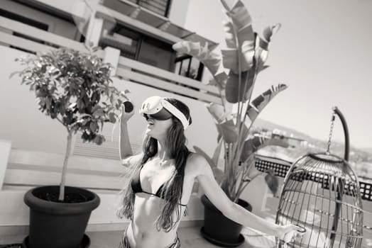 A stylish figure dressed in a fashionable bikini is enjoying rooftop relaxation amid lush greenery and warm sunlight
