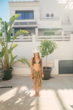 A stylish individual relishes the experience of a sunny day in a vibrant tropical setting, exuding summer elegance