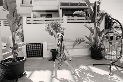 A vibrant dance performance, captured in black and white, takes place outdoors among lush greenery and nature