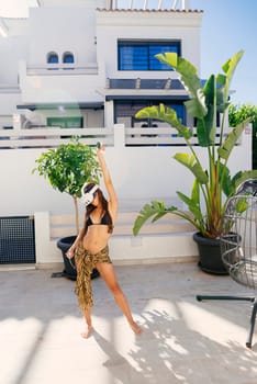 A stylish and fashionable model poses gracefully in a vibrant tropical setting, radiating summer energy and charm