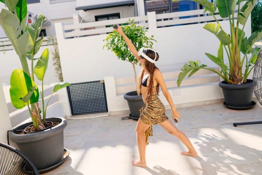A talented dancer passionately showcases vibrant energy and joy amidst lush tropical plants in a stylish outdoor space