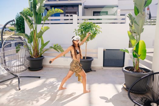 A vibrant dance scene unfolds in a sunlit tropical patio filled with lush plants and comfy furniture
