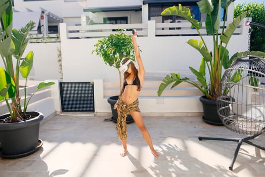 A graceful dancer strikes a dynamic pose in a lush tropical setting, surrounded by vibrant greenery