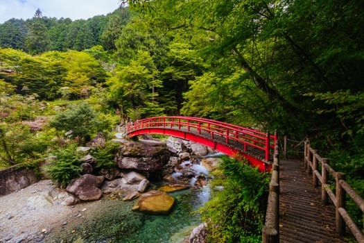 The magnificent Ryujin Falls and iconic red bridge at the start of autumn in Nakatsugawa City, near Sakashita in Japan