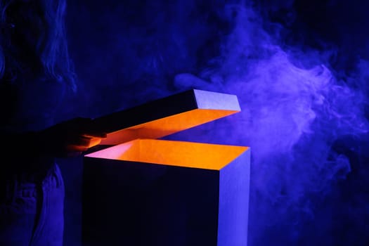 Man opens magic box with surprise on dark background, mystical box, surprise, halloween, monster box