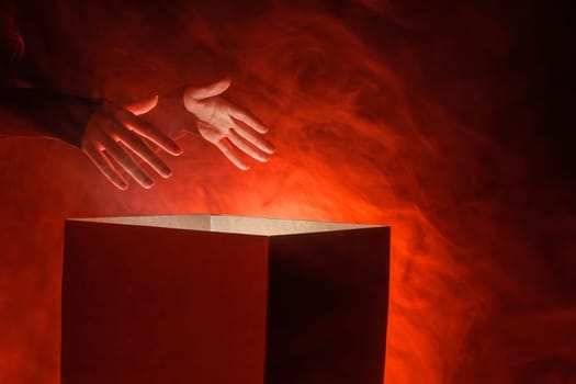 Man opens magic box with surprise on dark background, mystical box, surprise, halloween, monster box