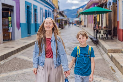Mother and her son tourists walks through the colonial streets San Cristobal de las Casas, Mexico. Cultural exploration, architecture, and travel experience concept.
