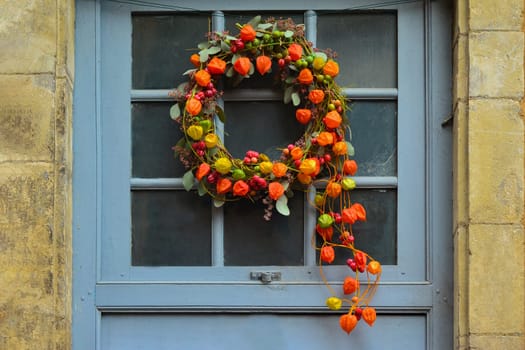 Wreath of autumn plants with physalis and red berries