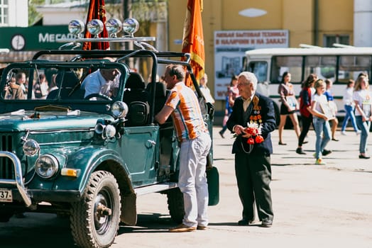 VICHUGA, RUSSIA - MAY 9, 2016: Veterans on car on the march of the immortal regiment and the parade on May 9 on Victory Day. Vichuga, Russia