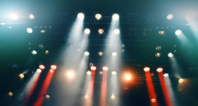 glowing ceiling spotlights lights the stage during the concert with Stage mist