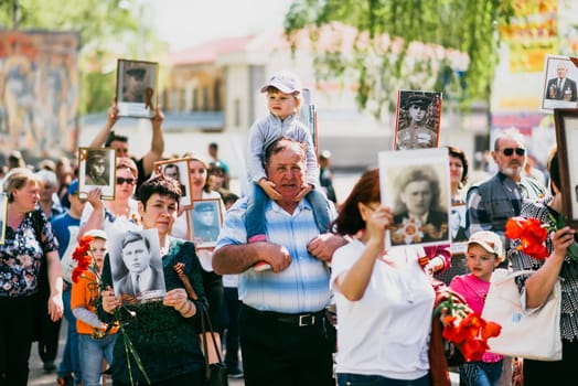 VICHUGA, RUSSIA - MAY 9, 2015: Immortal Regiment - people with portraits of their relatives, participants in the Second World War, on the Victory Day parade