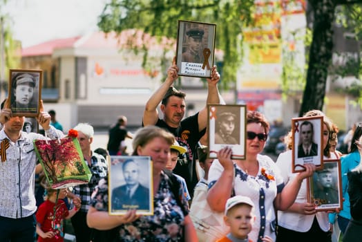 VICHUGA, RUSSIA - MAY 9, 2015: Immortal Regiment - people with portraits of their relatives, participants in the Second World War, on the Victory Day parade