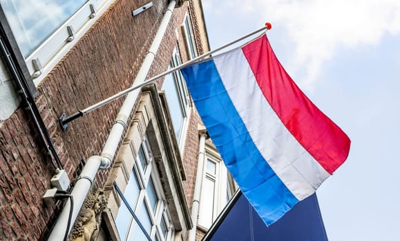 Netherlands flag on fasad building against Blue Sky