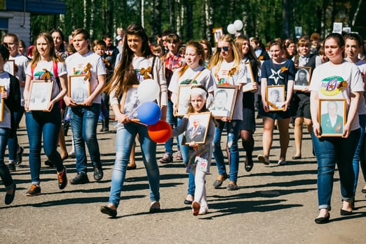 VICHUGA, RUSSIA - MAY 9, 2016: Immortal Regiment - people with portraits of their relatives, participants in the Second World War, on the Victory Day parade