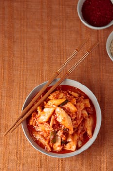 Kimchi, Kimchee in the Bowl, Red Spicy Kim Chi, Hot Fermented Napa Cabbage, Traditional Jimchi, Korean cuisine, top view banner with a copy space