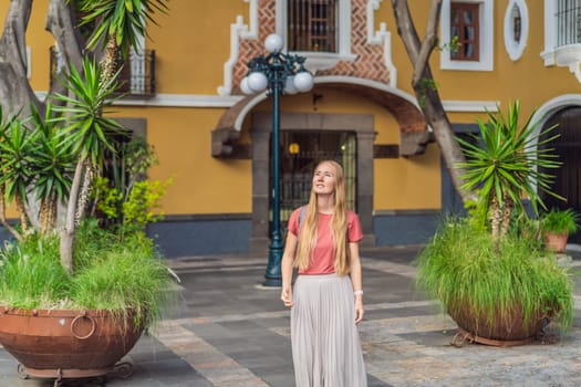 Female tourist walking through the colorful colonial streets of Puebla, Mexico. Travel, cultural exploration, and vibrant architecture concept.