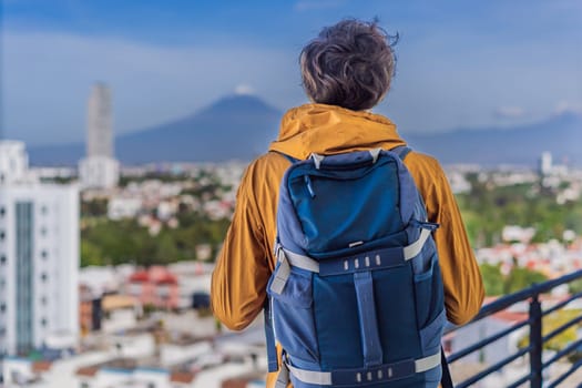 Male tourist in front of Popocatepetl Volcano, Mexico. Adventure, natural exploration, and travel experience concept.