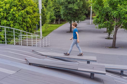 Teenage boy doing parkour in a park. Adventure, movement, and urban sport concept.