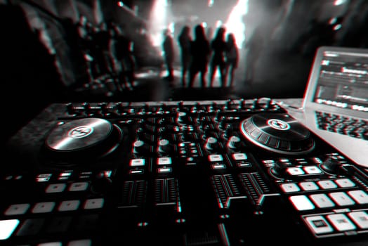 DJ mixer controller Board for professional mixing of electronic music in a nightclub at a party with dancing people in the background. Black and white photo with glitch effect and small grain