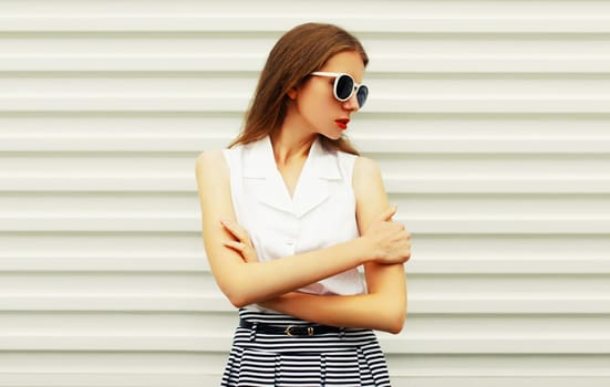 Portrait of beautiful young woman model posing wearing sunglasses on white background