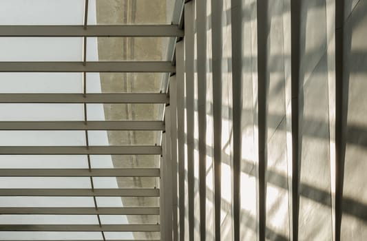 Bangkok, Thailand - 28 Sep, 2024 - View of Sunlight shining through glass roof and creating shadows on a wall. Modern architecture interior design of metal structure building with Burred light and shadow passing through glazed ceiling, Space for text, Selective focus.