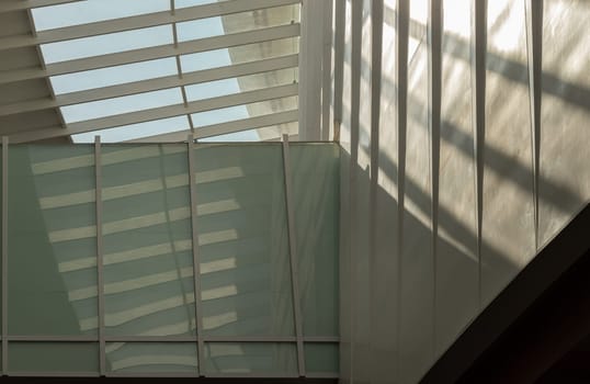 Bangkok, Thailand - 28 Sep, 2024 - Modern architecture interior design of metal structure building with Burred light and shadow passing through glazed ceiling. Abstract image of Sunlight shining through a glass roof and creating shadows on a wall, Copy space, Selective focus.