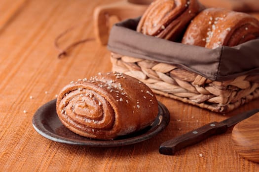 Korvapuusti, traditional finnish cinnamon and cardamom rolls, fresh baked buns on the plate, sweet dessert Sweden and Finland, horizontal banner with copy space