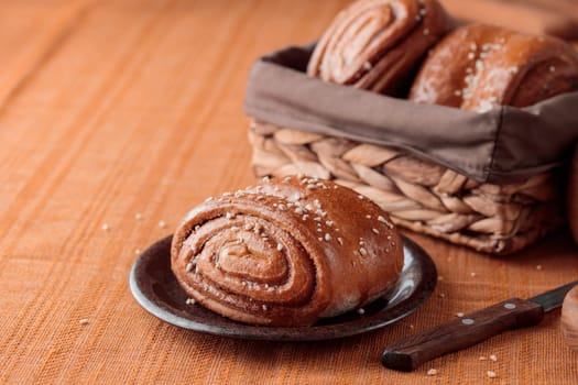 Korvapuusti, traditional finnish cinnamon and cardamom rolls, fresh baked buns on the plate, sweet dessert Sweden and Finland, horizontal banner with copy space