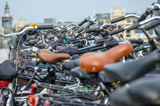 Netherlands. Many different bicycles on a bicycle parking lot against the background of blurred facades of old buildings in Amsterdam