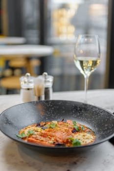 Salmon tataki in sauce with peanuts and herbs on a marble table in a restaurant. High quality photo