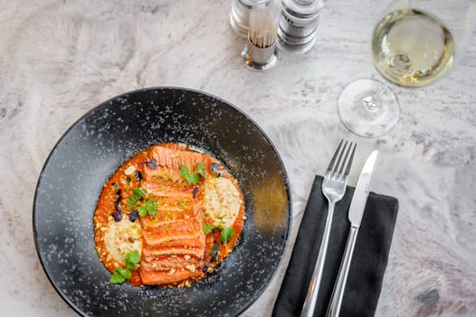 Salmon tataki in sauce with peanuts and herbs on a marble table in a restaurant. High quality photo