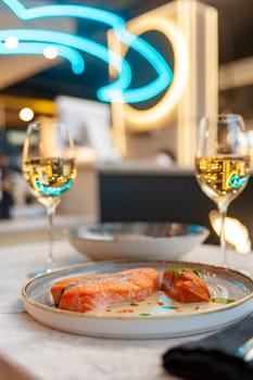 Salmon fillet in cream sauce with herbs on a marble table in a restaurant. High quality photo