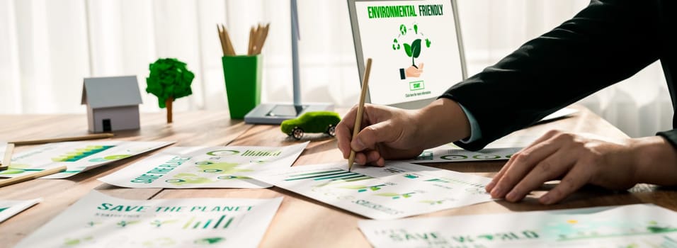 Businessman in green corporate company planning eco-friendly and environmental conservative to reduce CO2 and implement net zero policy in meeting room with eco idea on laptop screen. Trailblazing