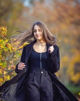 Happy girl spinning in the autumn park