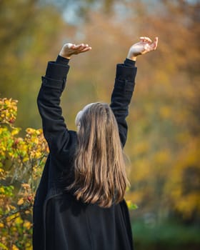 Happy girl spinning in the autumn park