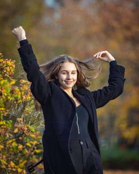 Happy girl spinning in the autumn park