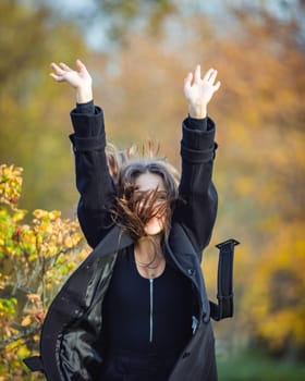 Happy girl spinning in the autumn park