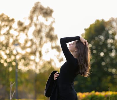 Beautiful girl posing in the sunshine in an autumn park