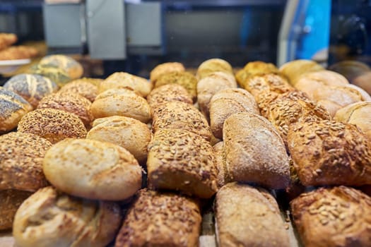 Close-up of a bakery pastry shop display with fresh buns. Delicious fresh pastries, flour food, bakery cafeteria small business concept