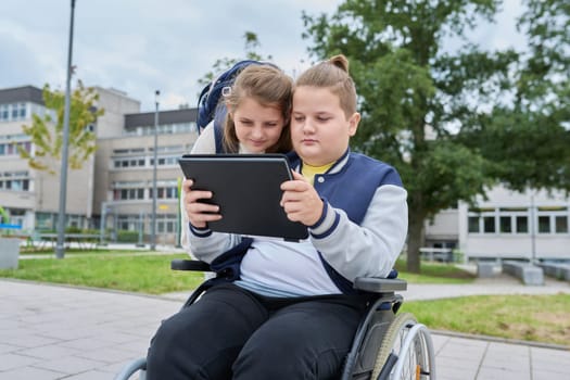 Children schoolchildren friends classmates together outdoor, girl and boy on wheelchair talking near school building. Education, friendship, communication, school, disability, inclusiveness concept