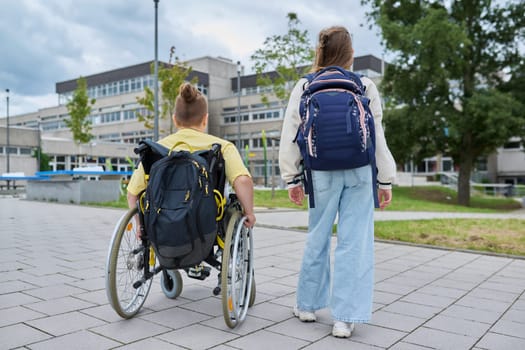 Children classmates going to school together, boy in wheelchair, girl with backpack, rear view. Education, friendship, communication, school, disability, inclusiveness concept