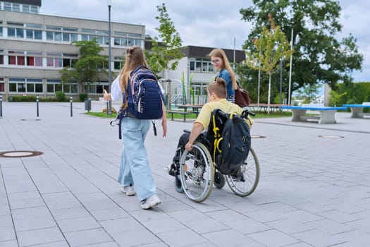 Back to school. Children going to school, boy in wheelchair and girls, rear view. Education, school, activity, childhood, disability, inclusiveness concept