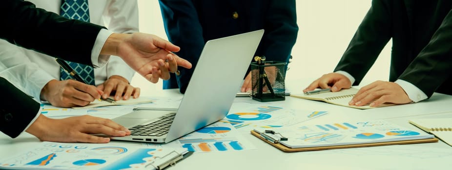 Business people in group meeting in formal attire share idea discussing report for company profit in creative workspace for start up business shot in close up view on group meeting table . Oratory .